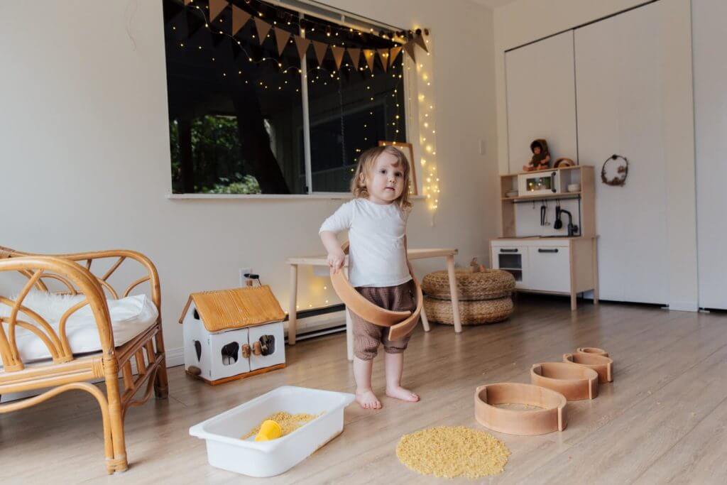 a toddler girl playing in her big playroom after cross-country moving with her family