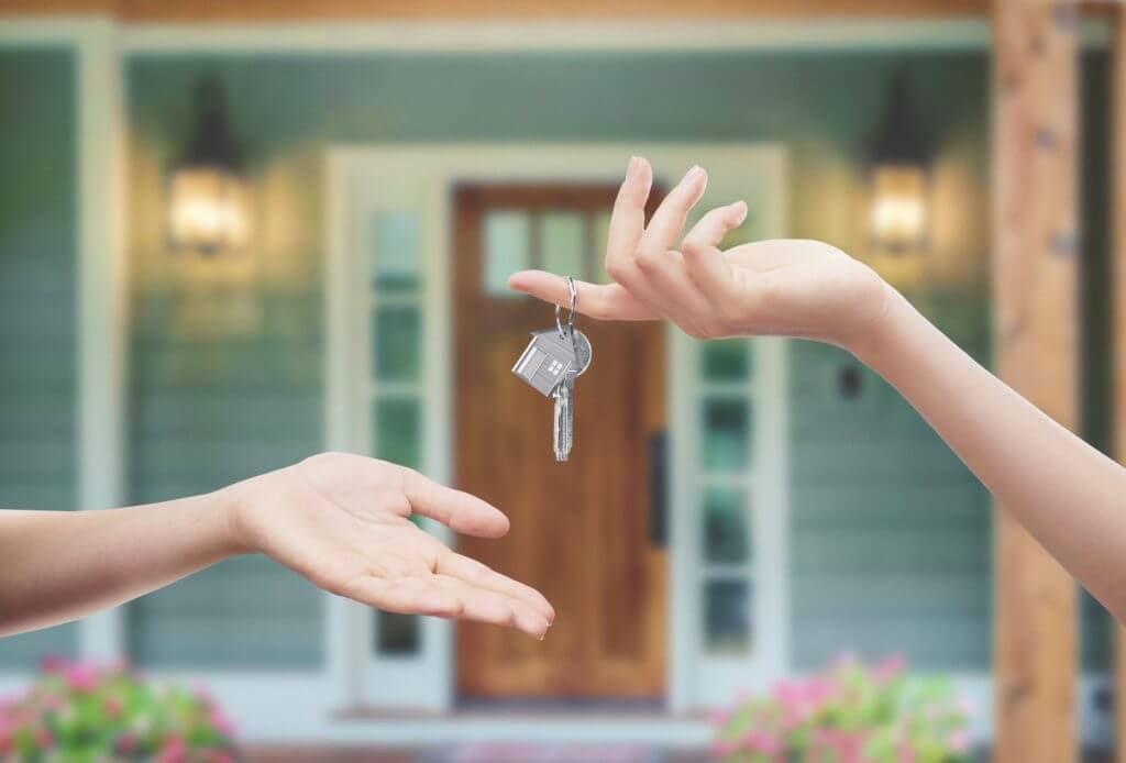 One hand giving house keys to another