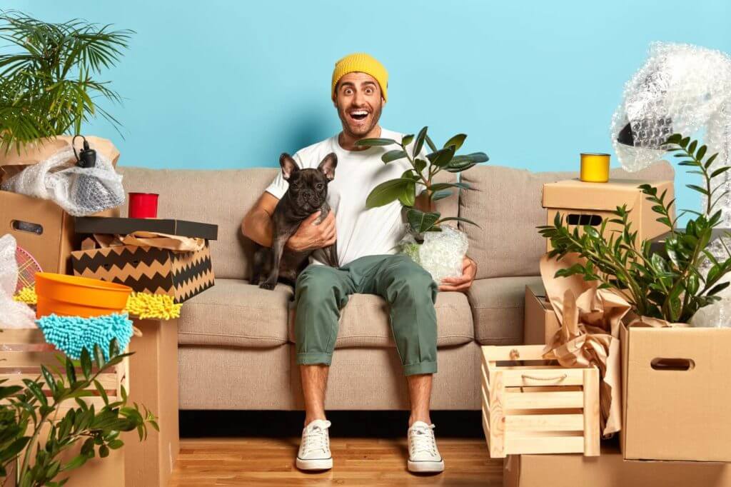 A guy with a dog and a plant