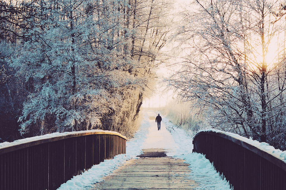 man walking on a snowy road