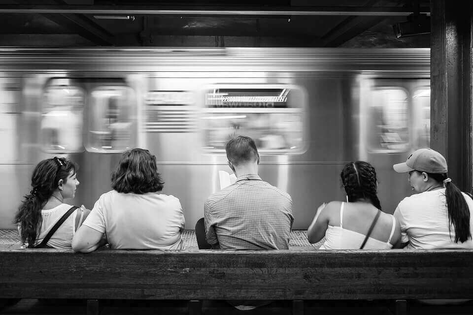 People are sitting on a bench in a subway
