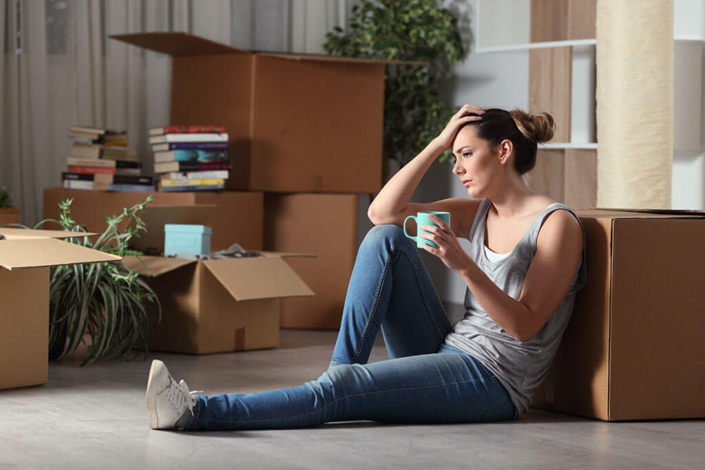 a girl with a mug sitting next to boxes