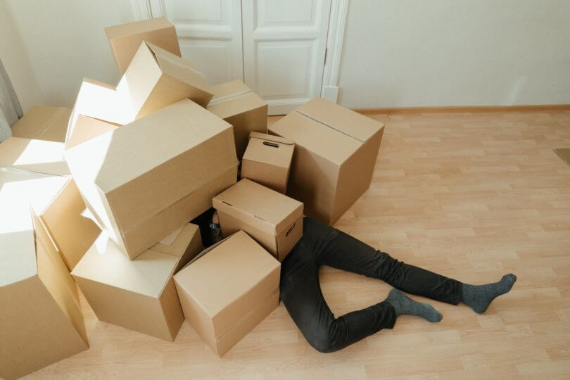 A man covered in boxes while lying on the floor