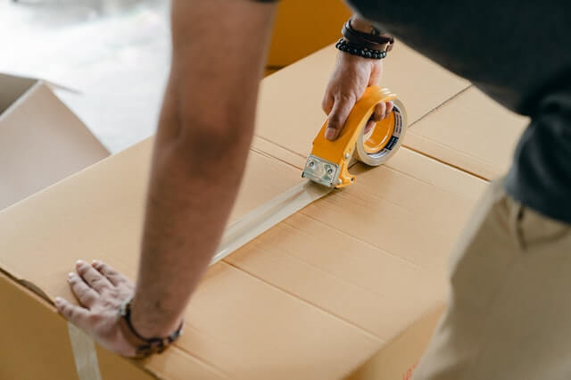 Man packing a box for long-distance moving