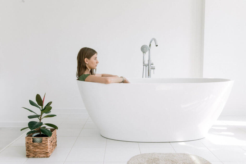 Woman laying in a bathtub after cross-country moving 
