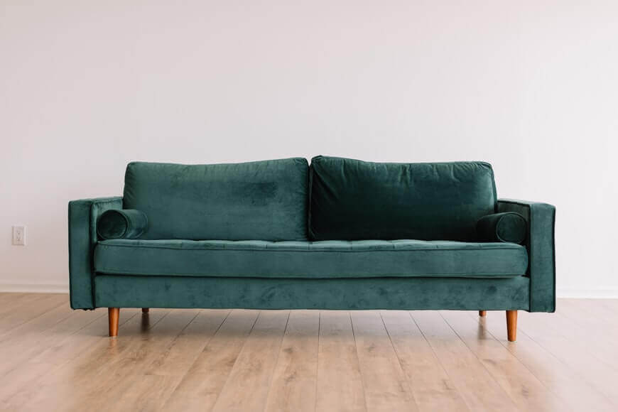 A green sofa with wooden legs