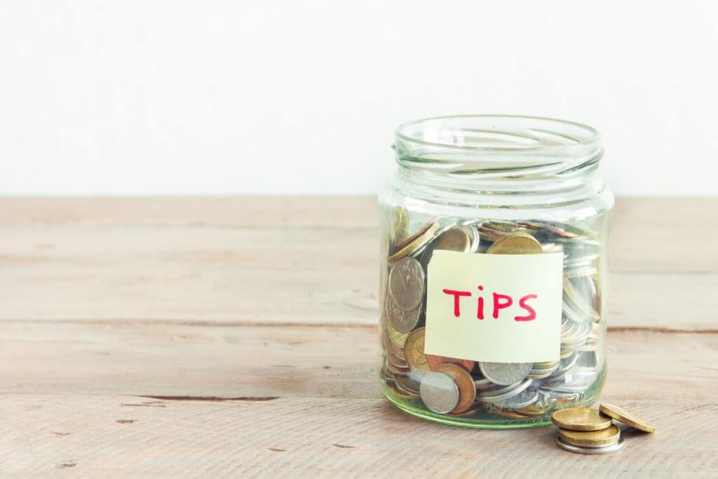 A jar for tips with nickels inside