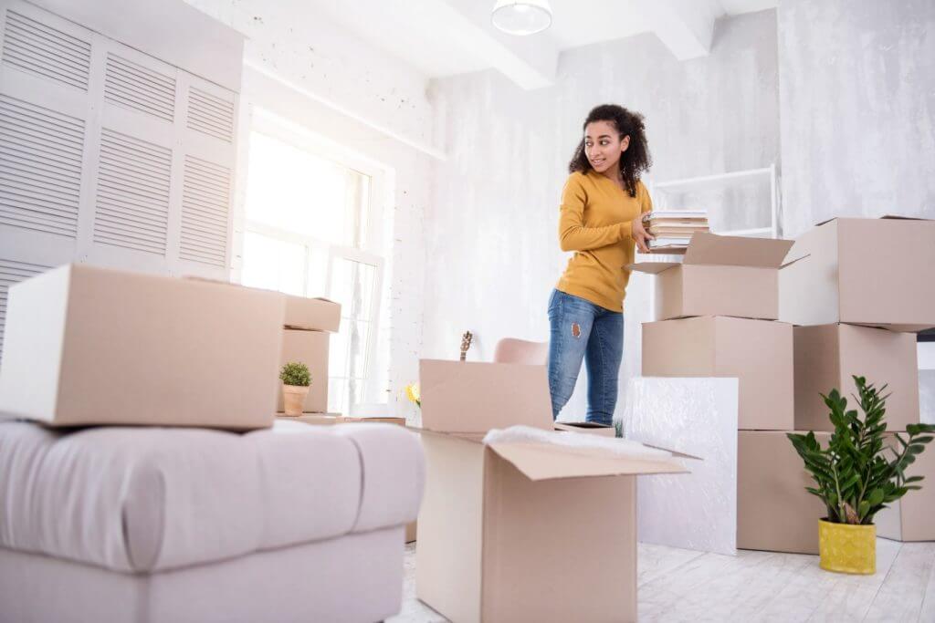 A girl surrounded by boxes before long-distance moving