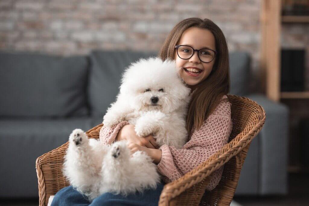 A girl sitting on a chair with a dog after cross-country moving 
