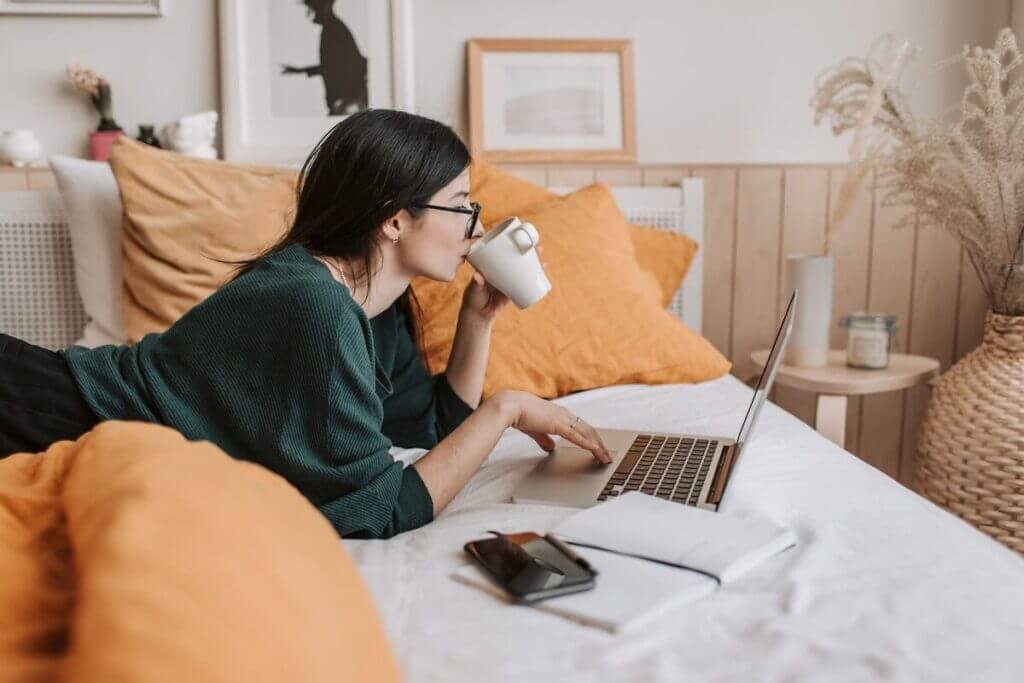 A woman drinking coffee and using her laptop 