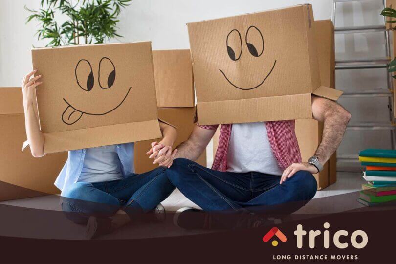 a couple with boxes Trico Long Distance Movers logo