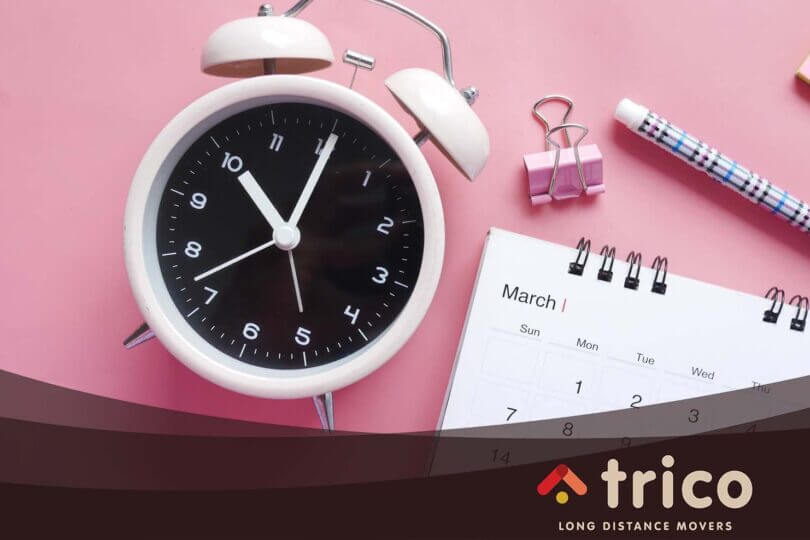 Alarm clock and calendar on pink background