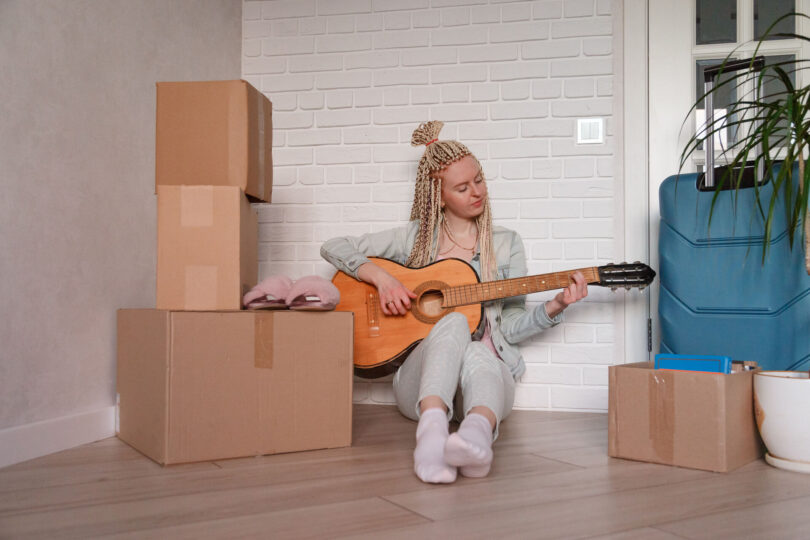 girl with a guitar and boxes