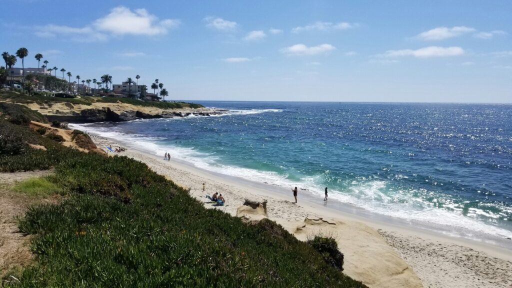 People enjoying the beach and coastal scenery at La Jolla Shores in San Diego.