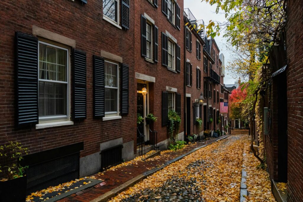 A classic brown brick apartment building surrounded by lush green trees during the daytime