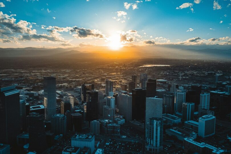 Sunset over a massive city skyline filled with high-rise skyscrapers.